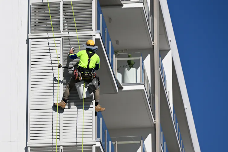 worker on white apartment building