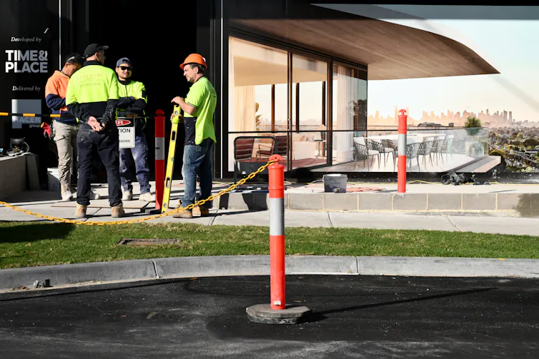 workers near new building with light-coloured path