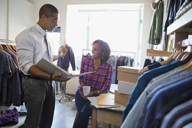 Business owners discussing paperwork in clothing shop
