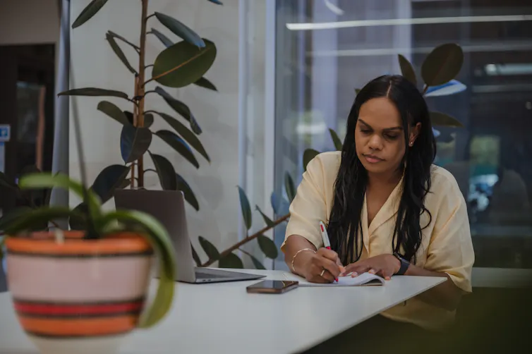 An Aboriginal woman works in an office.