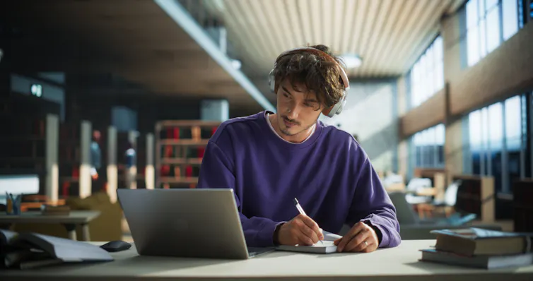 A journalism students works in a library.