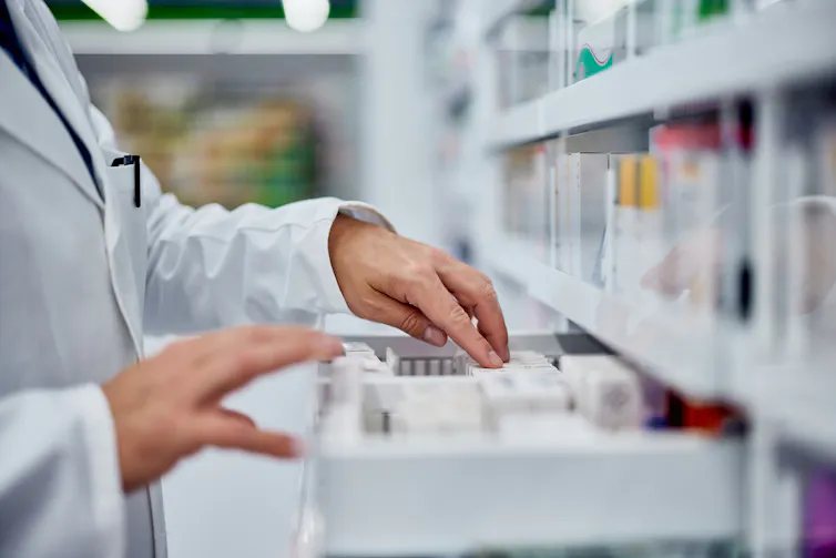 Pharmacist searching through drawer of drug packages