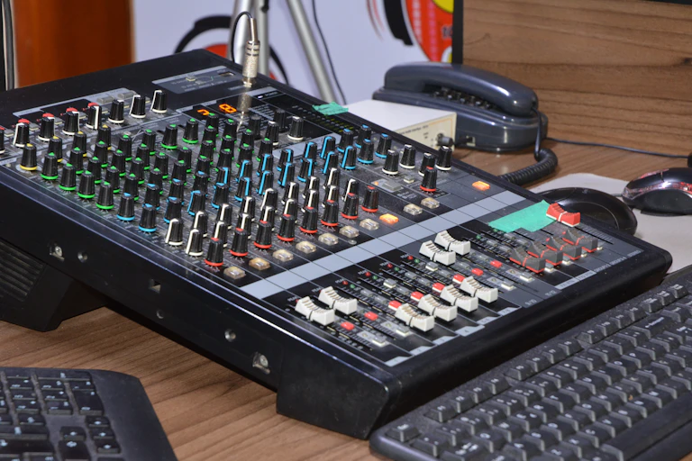 A radio sound board next to two black computer keyboards