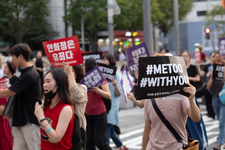A crowd of people in South Korea holding #MeToo placards.