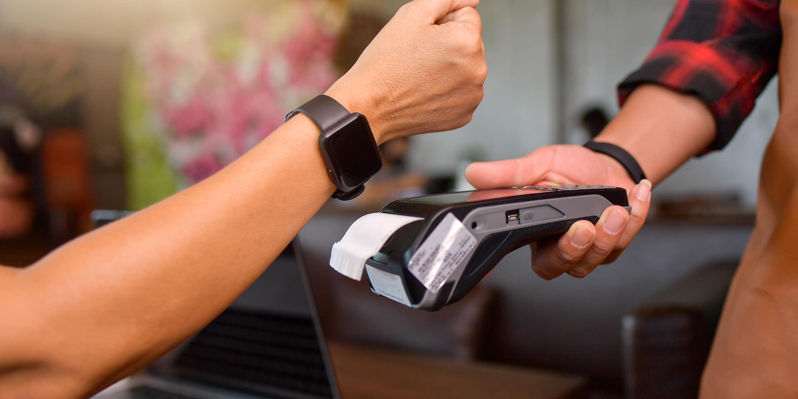 customer tapping their watch to make a mobile payment on a card reader