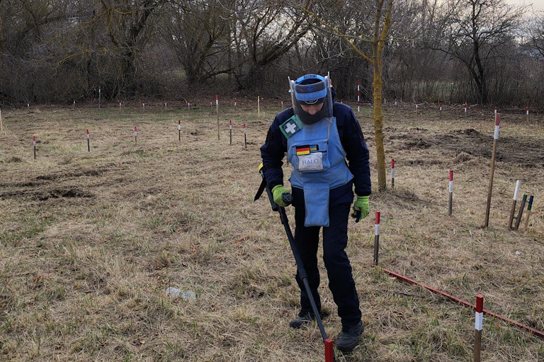 Un homme en uniforme bleu porte un détecteur de métaux