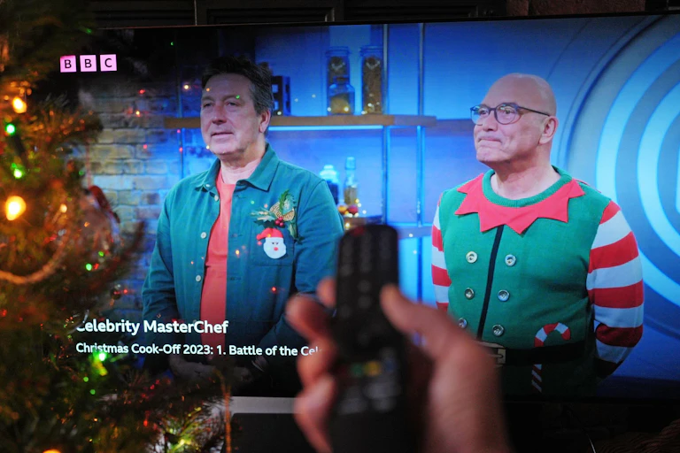 John Torode and Gregg Wallace on a TV with someone pointing a remote control at the screen.