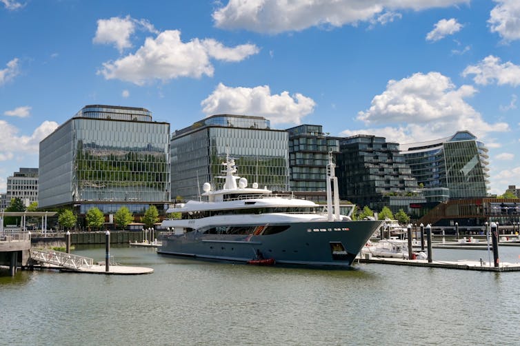 A yacht moored in front of apartment buildings.