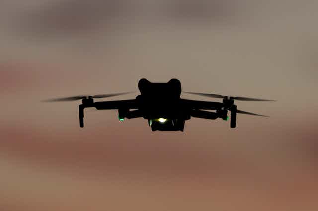 a quadcopter with lights flying in dim light