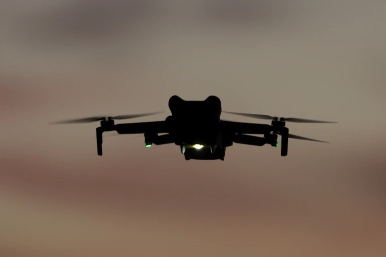 a quadcopter with lights flying in dim light
