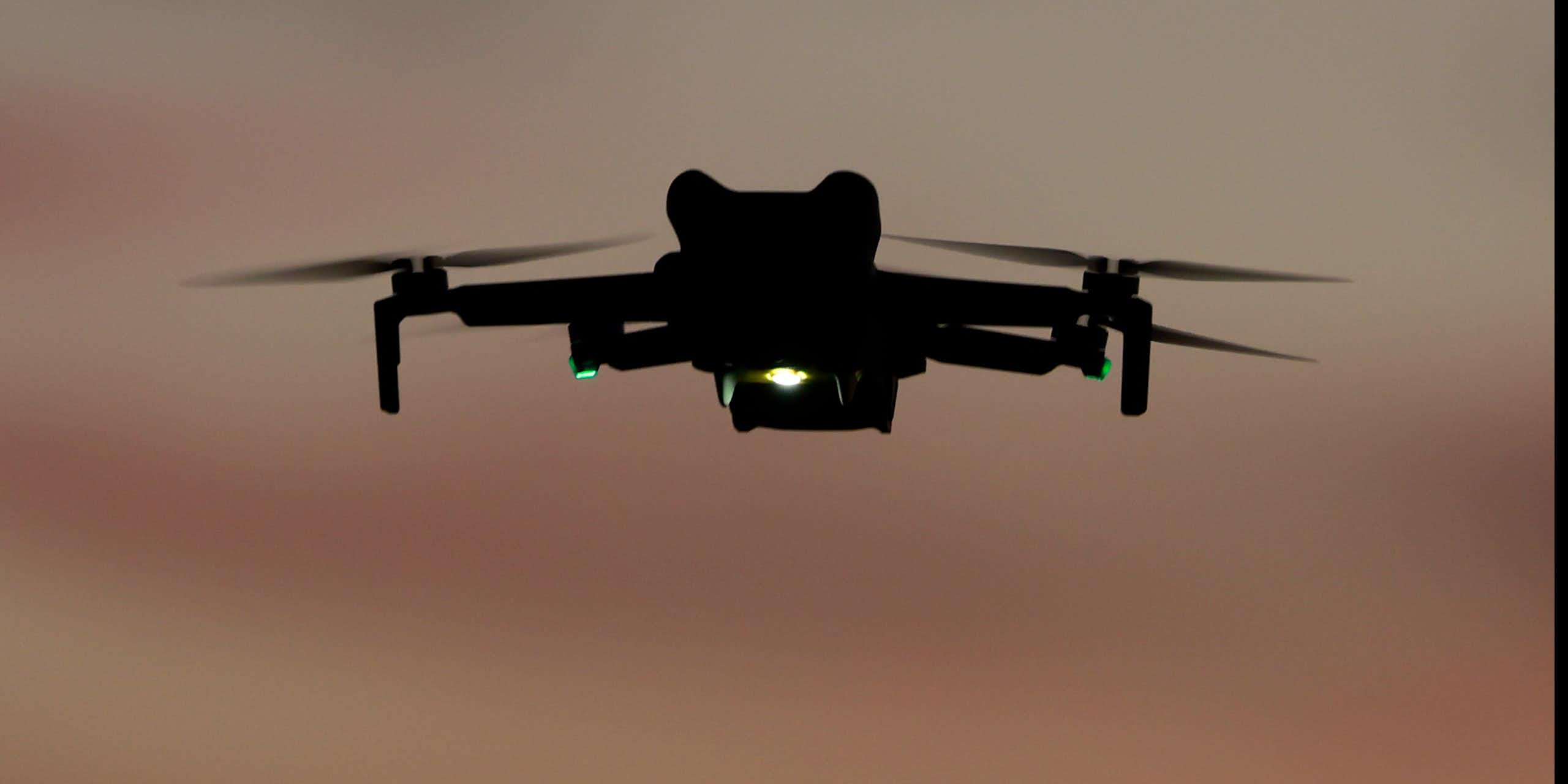 a quadcopter with lights flying in dim light