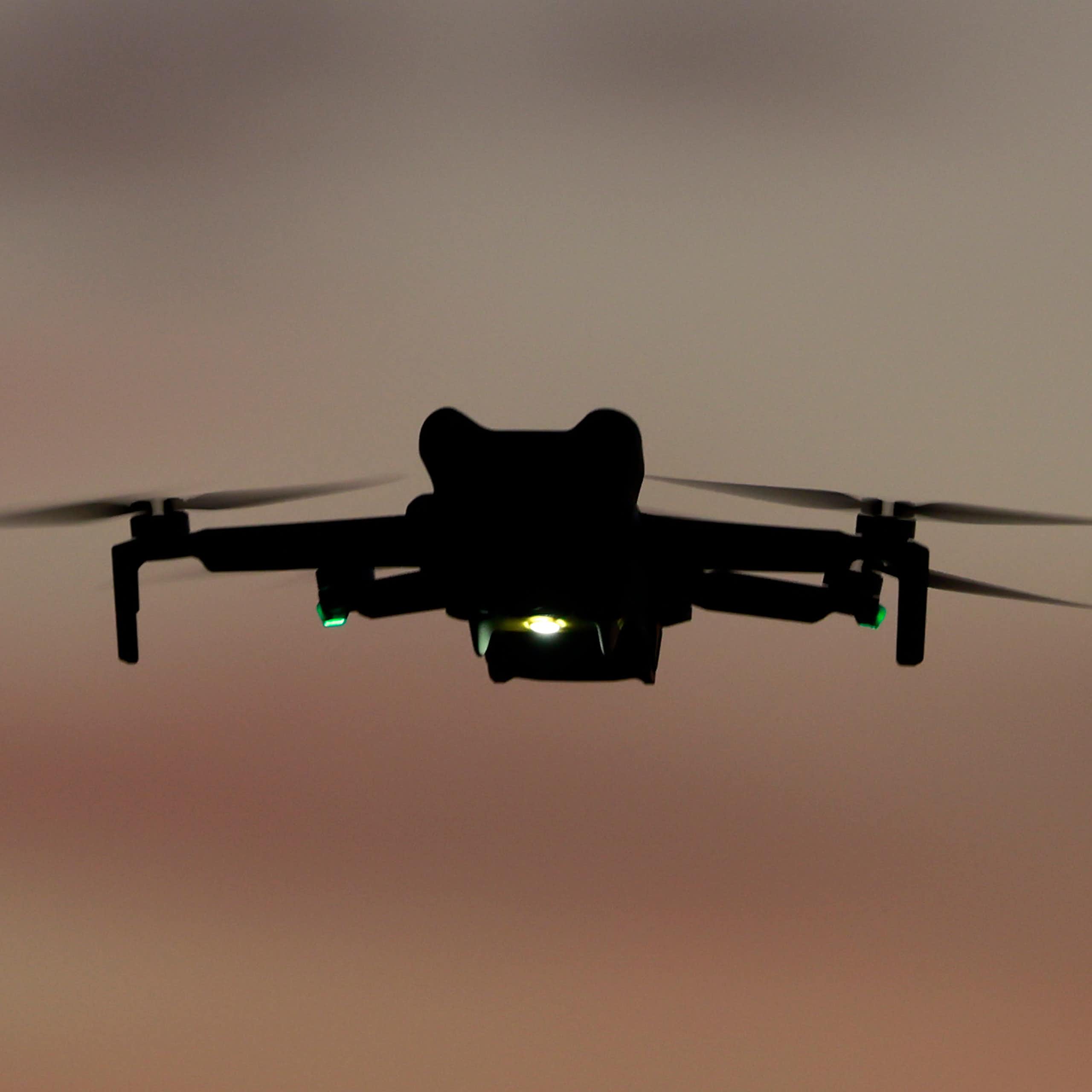 a quadcopter with lights flying in dim light
