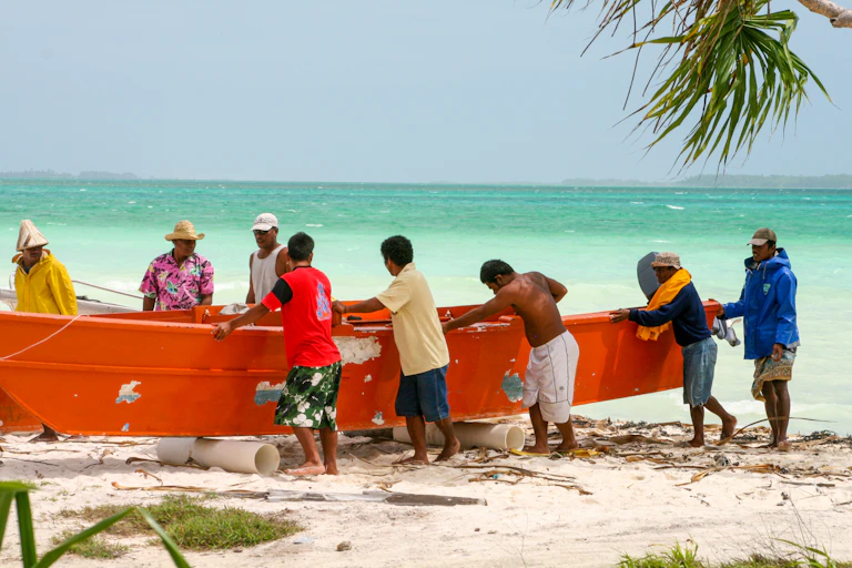 Men in Kiribati push a boat