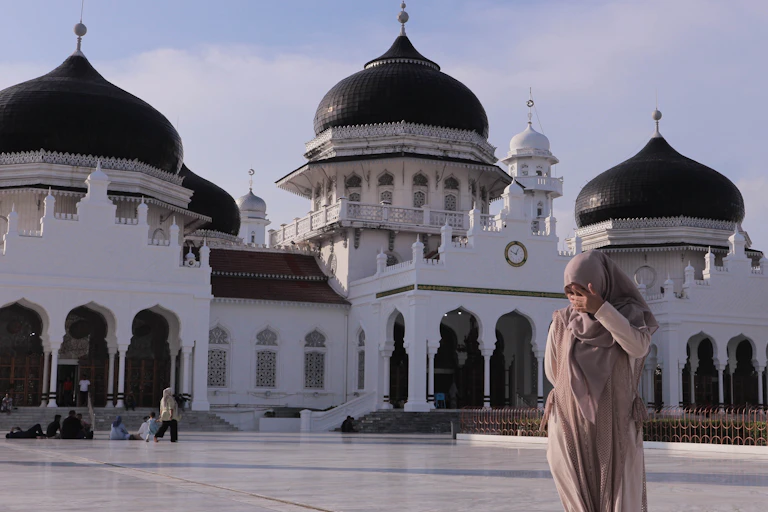 A woman standing in front of Masjid Raya Baiturrahman, Banda Aceh.