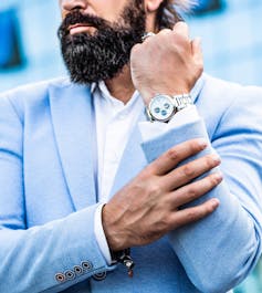 Man holding up arm showing expensive watch