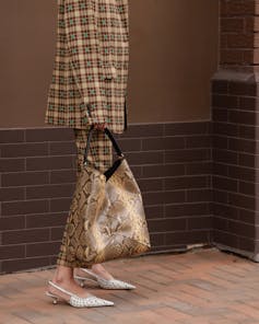 Woman in a luxury brand beige checkered jacket and trousers