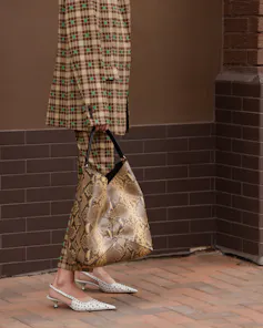 Woman in a luxury brand beige checkered jacket and trousers