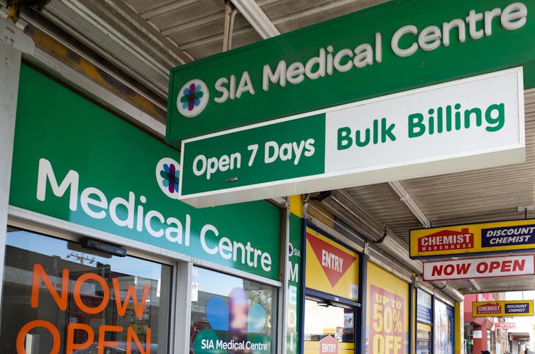 Signs on a shopping strip show a medical centre advertising bulk billing.