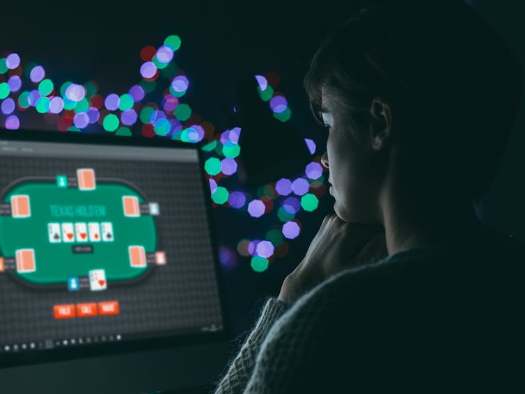A woman in dim lighting playing online poker