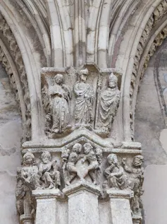 Capitel del claustro de León con tres figuras identificadas como Leonor de Guzmán (izquierda), Alfonso XI(centro) y el obispo obispo Juan del Campo (izquierda).