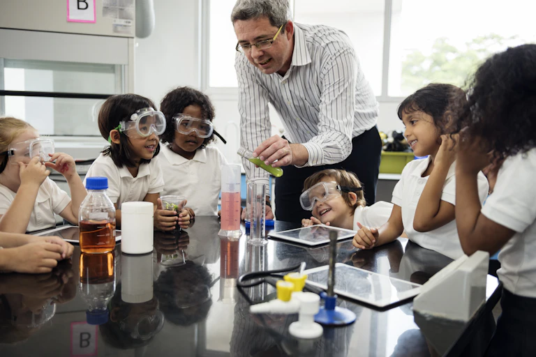 Teacher and primary school children in science class