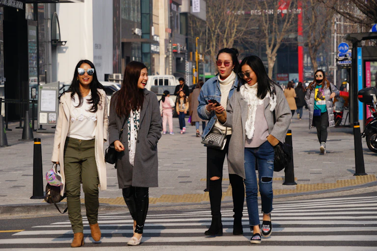 Four South Korean women walking across a road.