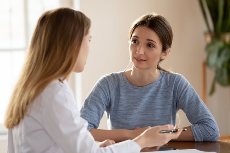 Mulher conversando com médico