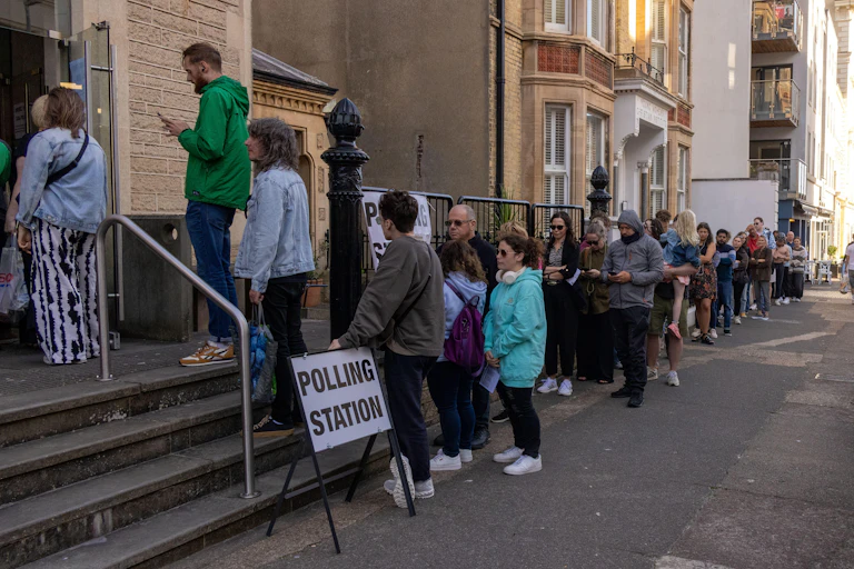 People queuing to enter a polling station.