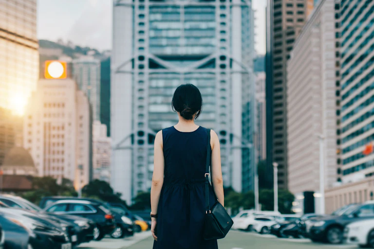 woman in cityscape faces away from camera