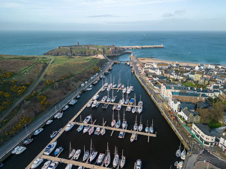 Poisonous chemical air pollution continues on Isle of Guy as executive defends Unesco conservation standing 1 aerial shot of coastal harbour with boats moored up
