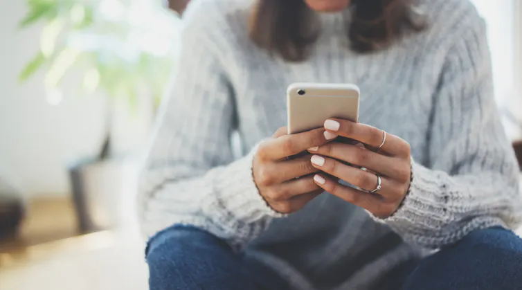 Woman's hands using a smartphone.