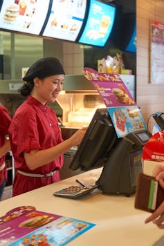 A worker takes a customer's order at a McDonald's restaurant