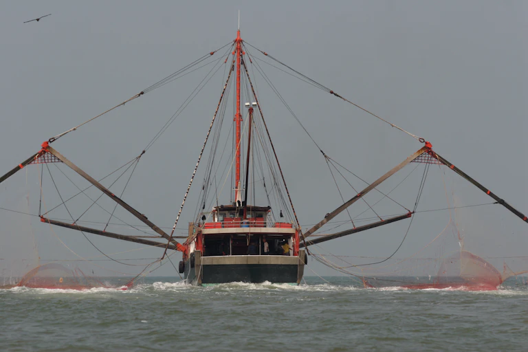 Fishing trawler on the water with nets spread wide