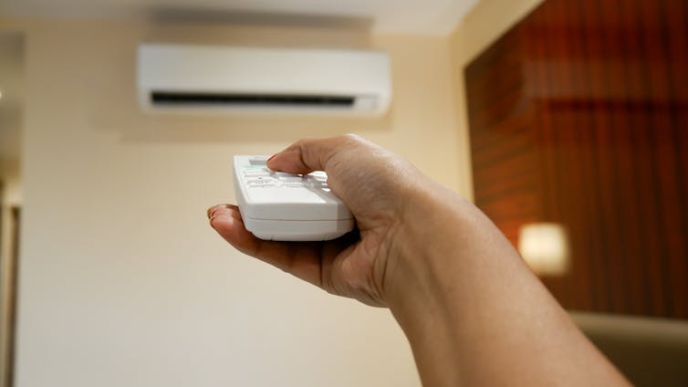 hand turning on air conditioning