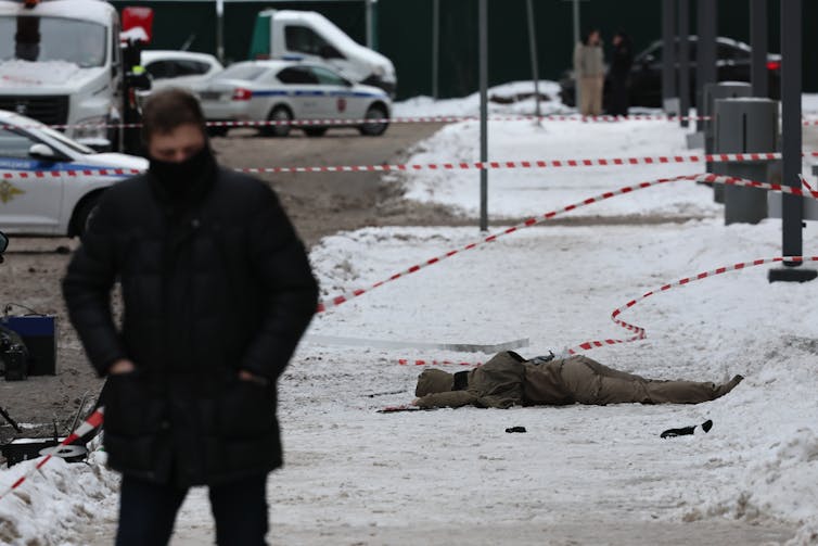 An investigator stands in front of the scene of the death of Igor Kirillov and an aide in an explosion.