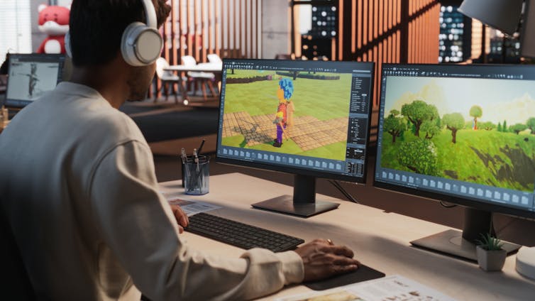 A person, seen from behind, working on a 3D modelling project on a computer