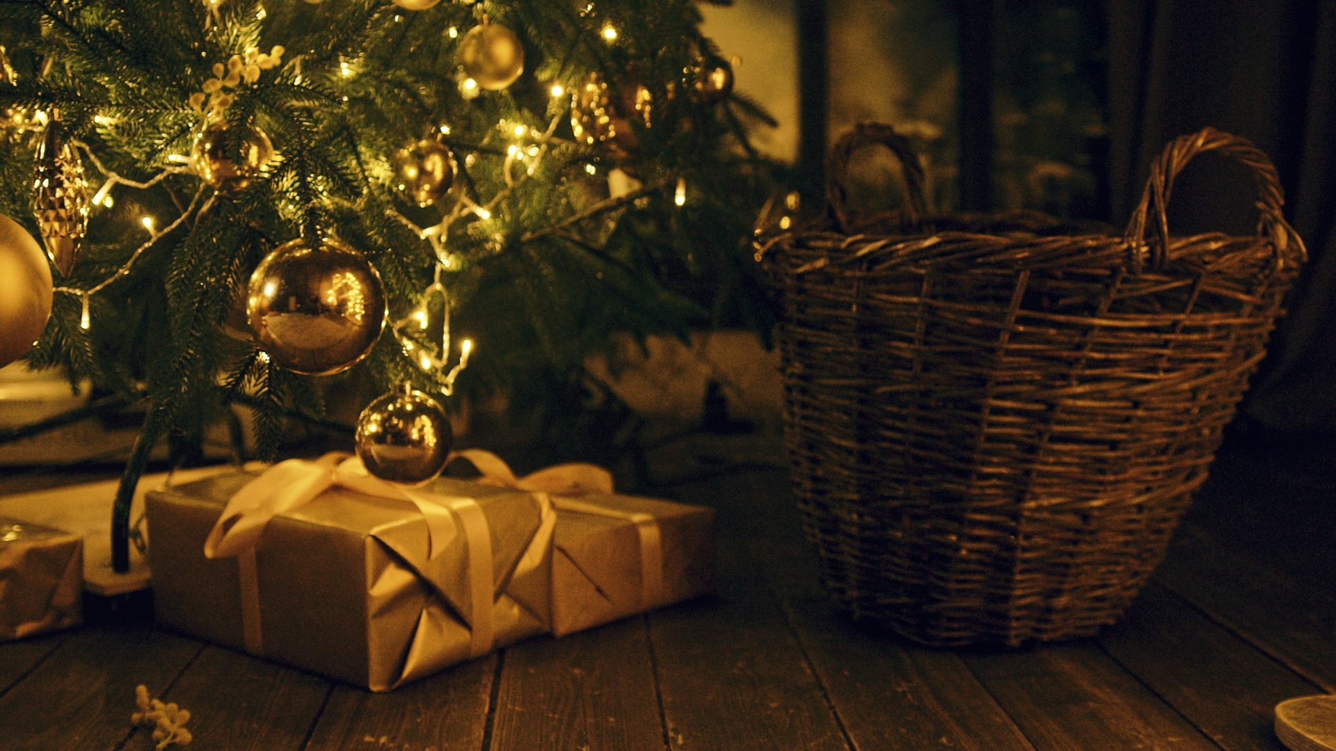 presents at the foot of a christmas tree. the light is golden.