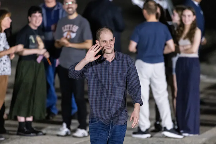 Wall Street Journal reporter Evan Gershkovich waving to cameramen.