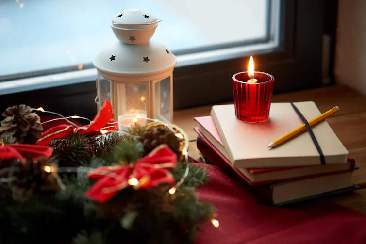 Christmas decorations next to a stack of notebooks.