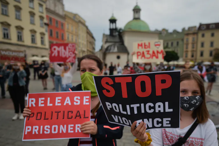 Protestors hod up siugns saying 'stop political violence'.
