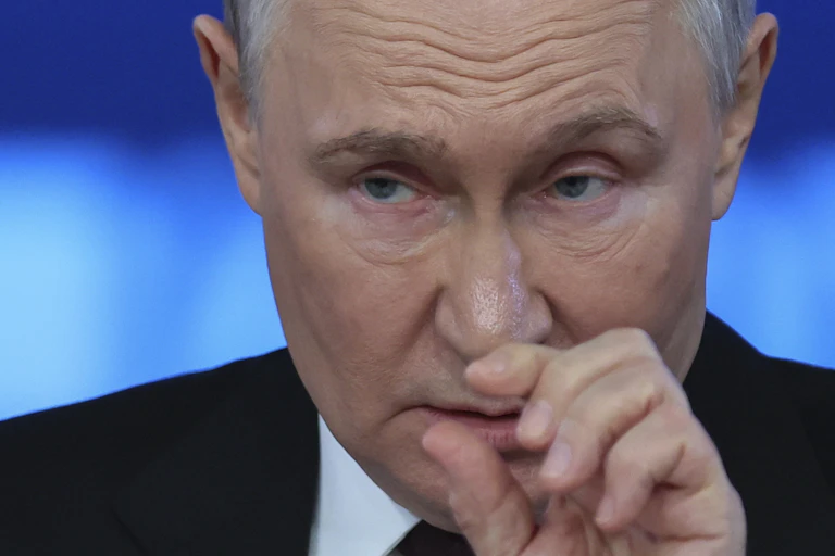 Putin gestures as he answers questions from reporters.