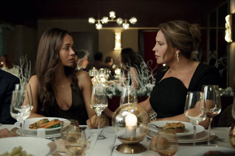 Dos mujeres se miran sentadas en una mesa de un restaurante.