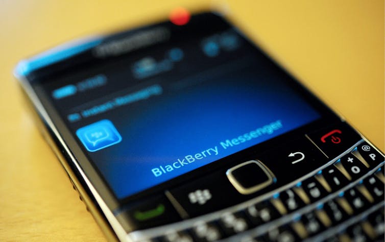 A smartphone with the words 'Blackberry Messenger' displayed on the screen