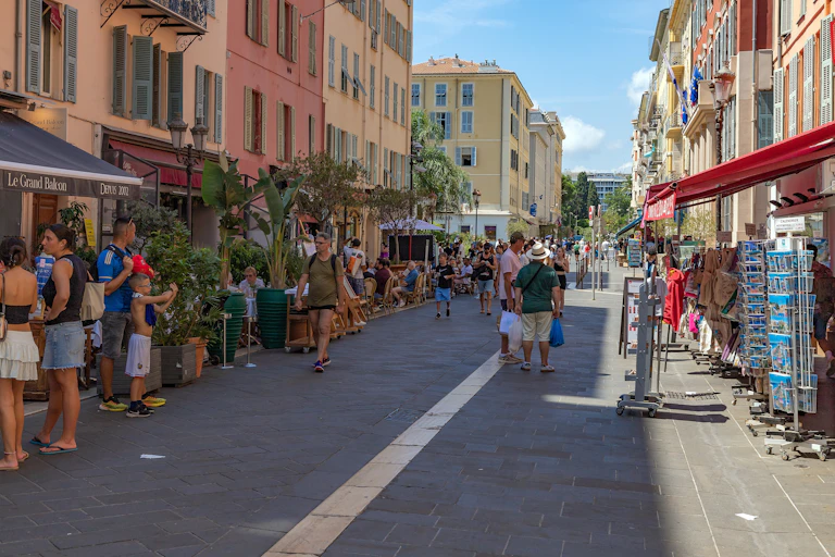 Des touristes s'arrêtent devant des magasins à Nice.