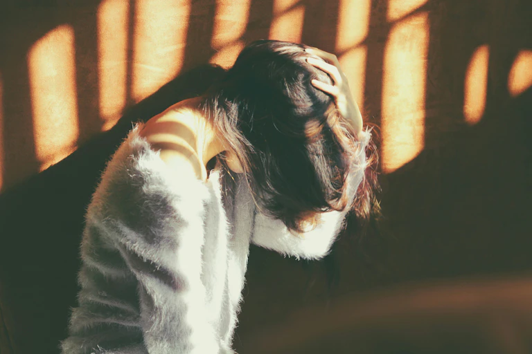 Jeune femme se tenant la tête.