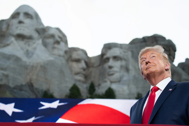 Donald Trump devant le Mont Rushmore et un drapeau américain
