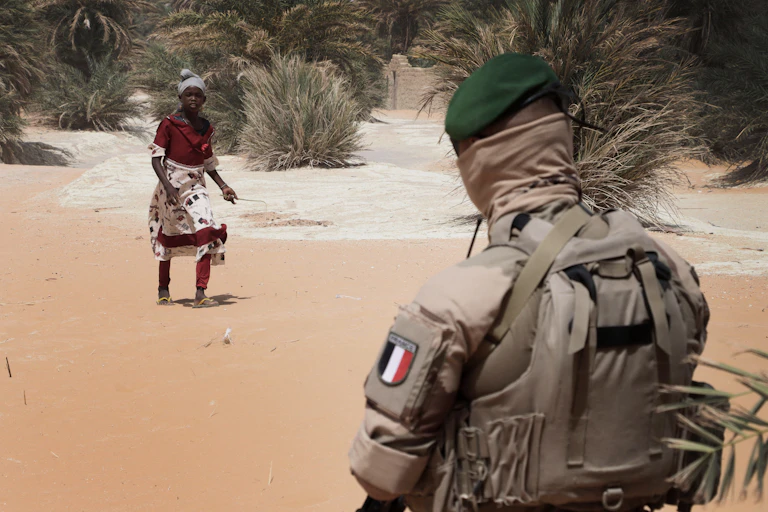 Une jeune femme passant devant un militaire français