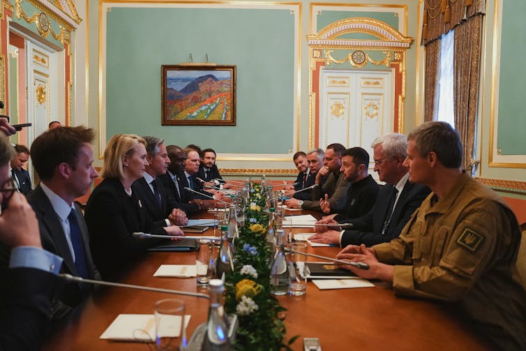 British officials meeting Ukrainian officials across a table.