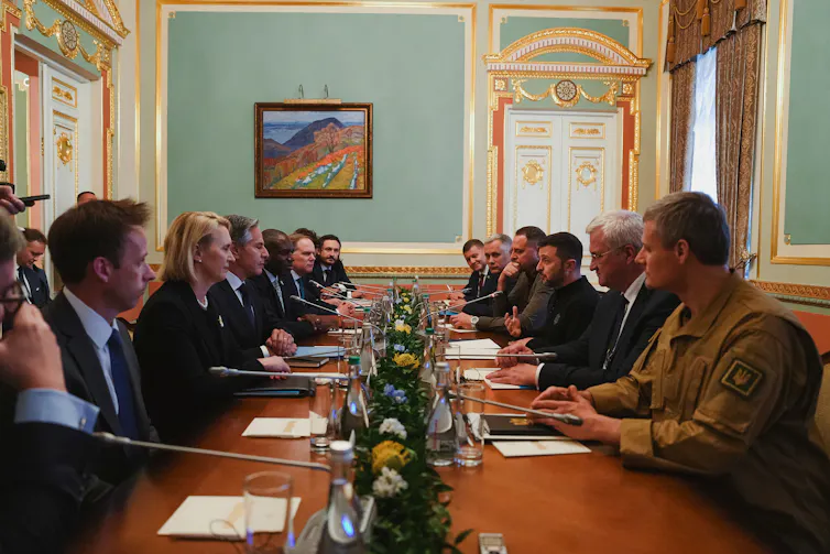 British officials meeting Ukrainian officials across a table.