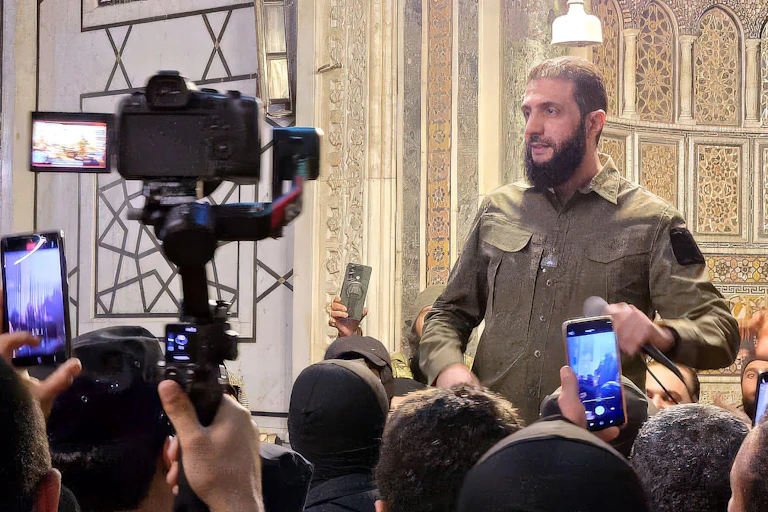 HTS leader Ahmed Al-Shara, also known as Abu Muhammad Al-Jolani talks to the press, December 2024.